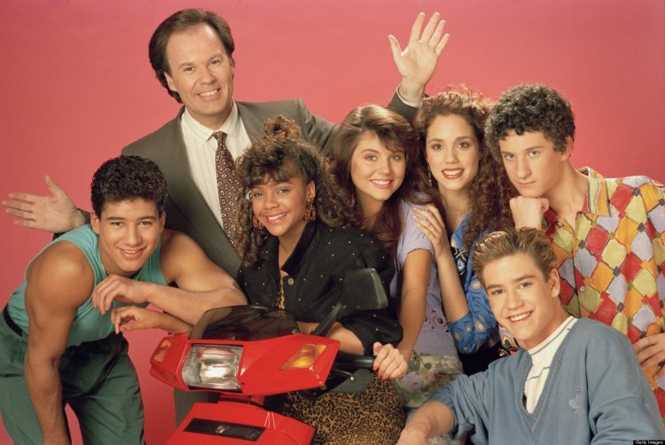 The cast of Saved By The Bell season 2. (Pictured: (L-R) Mario Lopez as Alabert Clifford 'A.C.' Slater, Dennis Haskins as Mr. Richard Belding, Lark Voorhies as Lisa Turtle, Tiffani Thiessen as Kelly Kapowski, Elizabeth Berkley as Jessie Spano, Mark-Paul Gosselaar as Zachary 'Zach' Morris, Dustin Diamond as Screech Powers. (Photo: NBCU Photo Bank)